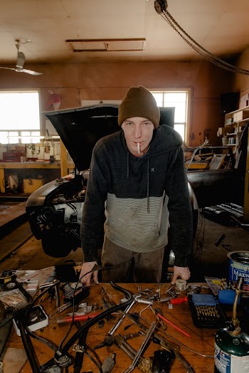 Smoking and Standing Man in Front of Table With Tools