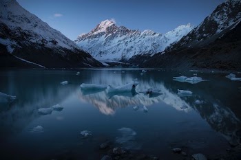 snow capped mountain near body of water during daytime