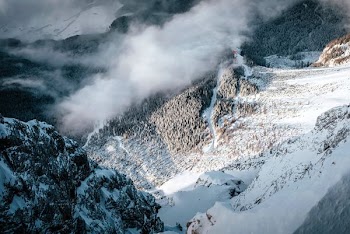 snow capped mountains covered with smoke during daytime