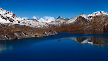snow coated mountain beside body of water