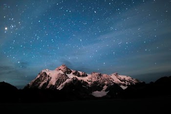 snow coated mountain under blue sky