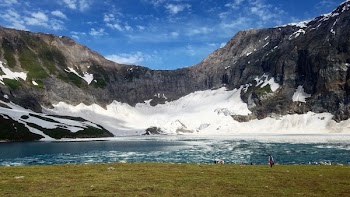 Snow Covered Cliff Near Body of Water Photo