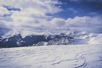 Snow Covered Hills Under White Clouds