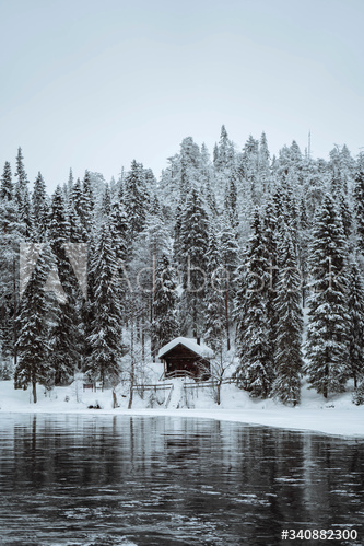 Snow-covered hut by  river in the Oulanka National Park, Finland