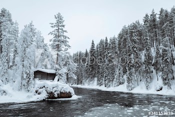 Snow-covered hut by  river in the Oulanka National Park, Finland