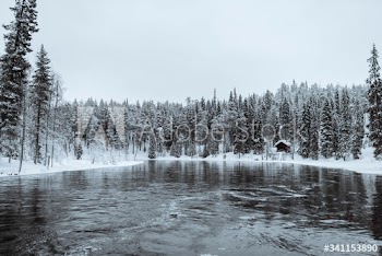 Snow-covered hut by  river in the Oulanka National Park, Finland