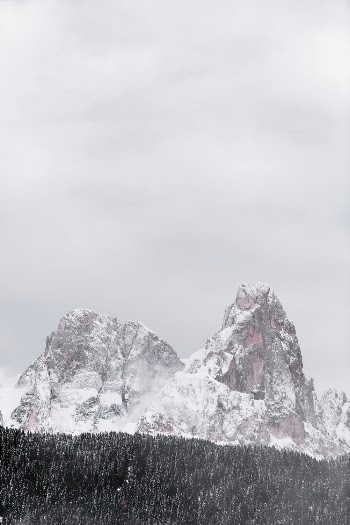 Snow Covered Mountain by Forest during Winter Season