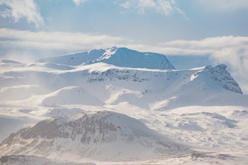 Snow Covered Mountain Ranges Under the White Skies