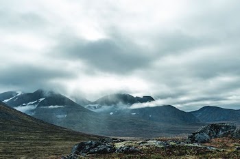 snow covered mountain reaching clouds