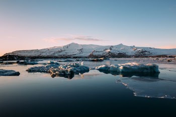 snow covered mountain under white and blue skies