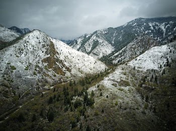 snow covered mountains under white clouds at daytime