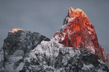 Snow Covered Rocky Mountain Under Cloudy Sky