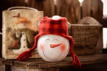 Snowman Glass Figurine on Brown Wooden Surface