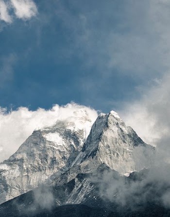 snowy mountain covered by clouds