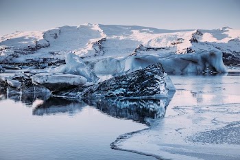 snowy mountains in middle of body of water