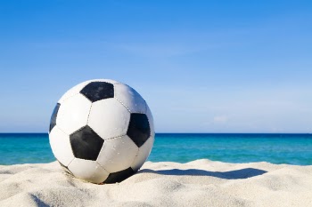 Soccer Ball On Sand Near Body Of Water