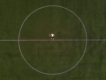 Soccer Player Laying In The Center Circle