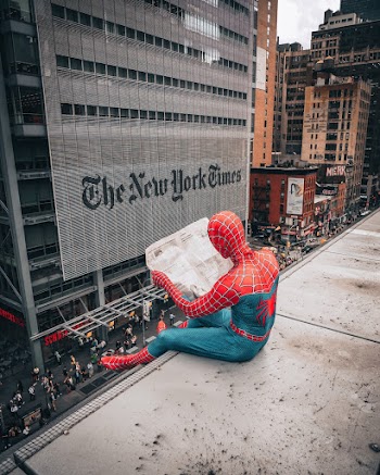 Spiderman Reading Newspaper on Top of Building