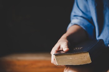 Spirituality and religion, hands folded in prayer on a holy bible in church concept for faith. Free Photo