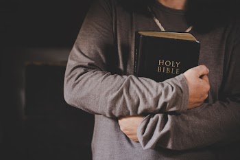 Spirituality and religion, hands folded in prayer on a holy bible in church concept for faith. Free Photo