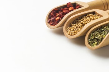Spoons with spices herbs on table Free Photo