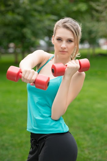 Sports girl exercise with  dumbbells in the park Free Photo