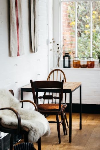 square brown and black table with chairs set on brown parquet flooring