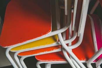 stacked of orange and yellow metal chairs