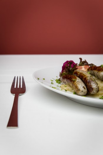 Stainless Steel Fork Near White Ceramic Round Plate With Sausage