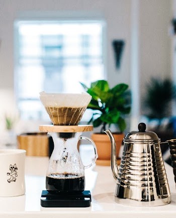 stainless steel kettle near glass pitcher with coffee filter