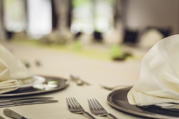 Stainless Steel Spoon on Top of White Table Cover Near Plate