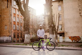 Standing Man Beside Green Road Bike
