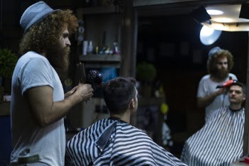 Standing Man Holding Blower Beside Sitting Man