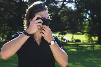 Standing Man Holding Camera and Taking Photo