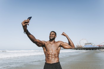Standing Man on Seashore Taking Selfie