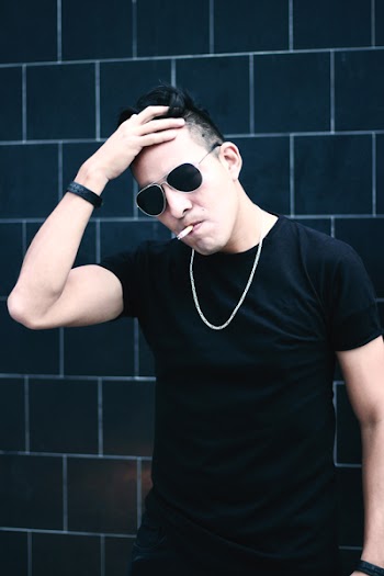 Standing Man Wearing Black Crew-neck T-shirt While Touching His Forehead