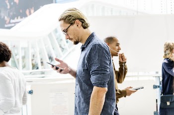 Standing Man While Using Smartphone Near People