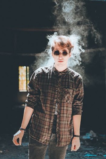 standing man with smoke near head