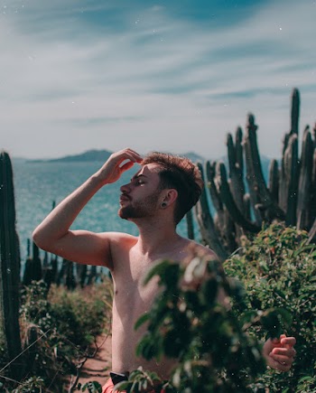 Standing Topless Man Beside Plants