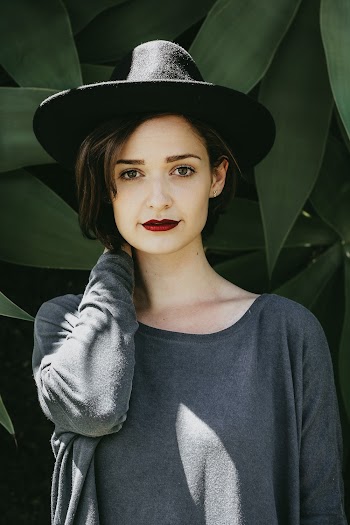 Standing Woman in Gray Sweater Behind Plants