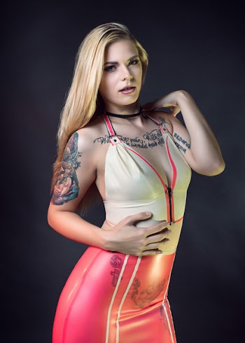 Standing Woman Wearing Beige and Pink Halter-strap Top and Pink Bottoms Holding Right Hand on Tummy
