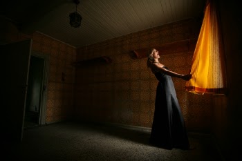 Standing Woman Wearing Black Dress Holding Curtain
