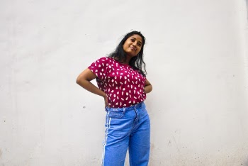 Standing Woman Wearing Maroon Shirt And Blue Pants