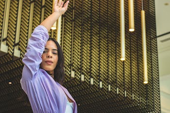 Standing Woman Wearing Purple Shirt Raising Her Right Hand