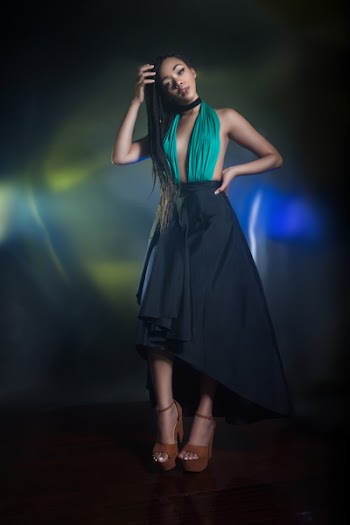 Standing Woman Wearing Teal and Black Halter Dress