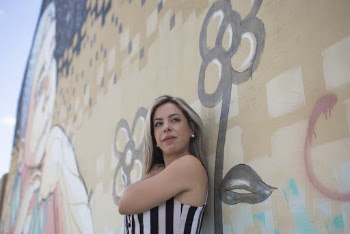 Standing Woman While Leaning on Graffiti Wall