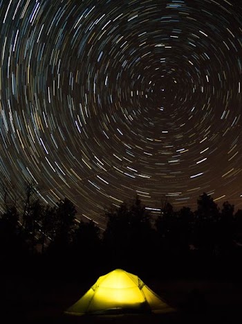 star trail photography of yellow camping tent