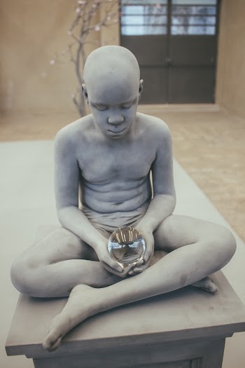 Statue of Boy Holding Glass Ball
