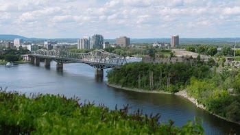 steel bridge, body of water, and city during daytime