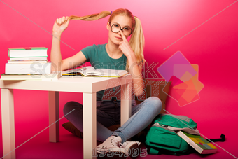 Stock Photo of Playful schoolgirl with two hair tails sitting on ...